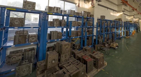 Metal moulds on blue racks in a workshop